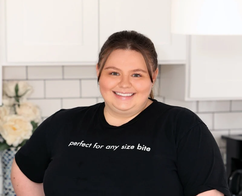 Smiling chef in a Tiny Spoon Chef T-shirt in a home kitchen
