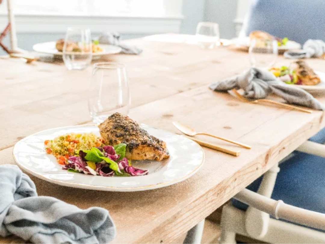 Plated fish dinner with salad on a set dining table